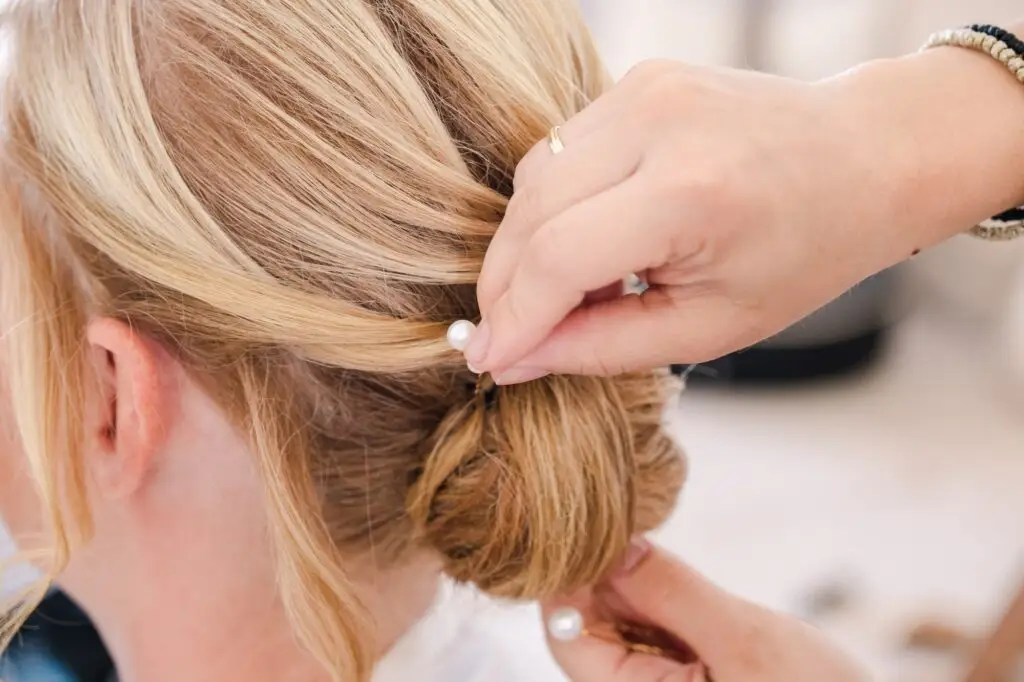Préparatifs de la mariée lors d’un mariage à Rethymnon en Crète, coiffure élégante avec perles photographiée par Julien Boyer photographe de mariage