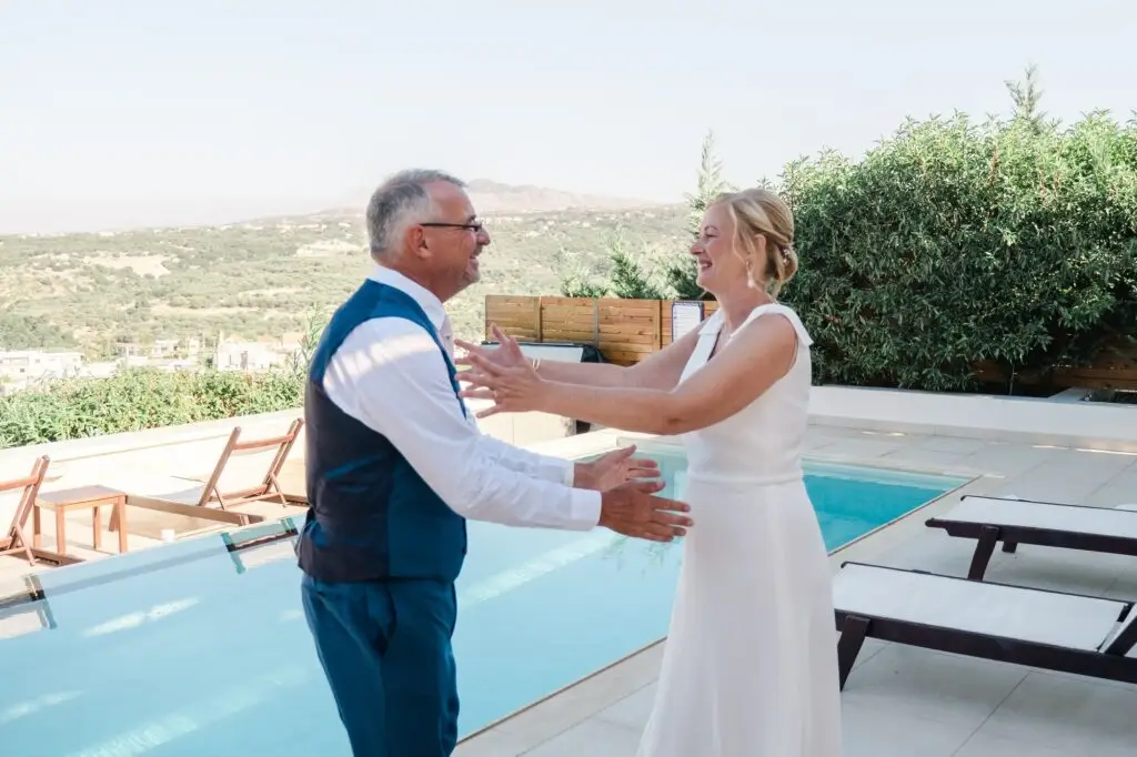 Étreinte des mariés lors de leur mariage à Rethymnon en Crète, moment spontané au bord de la piscine capturé par Julien Boyer photographe de mariage