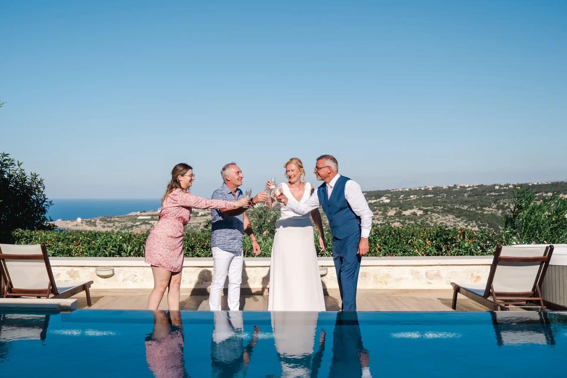 Toast de mariage avec les proches à Agreco Farm près de Rethymnon en Crète, célébration conviviale au bord de la piscine photographiée par Julien Boyer