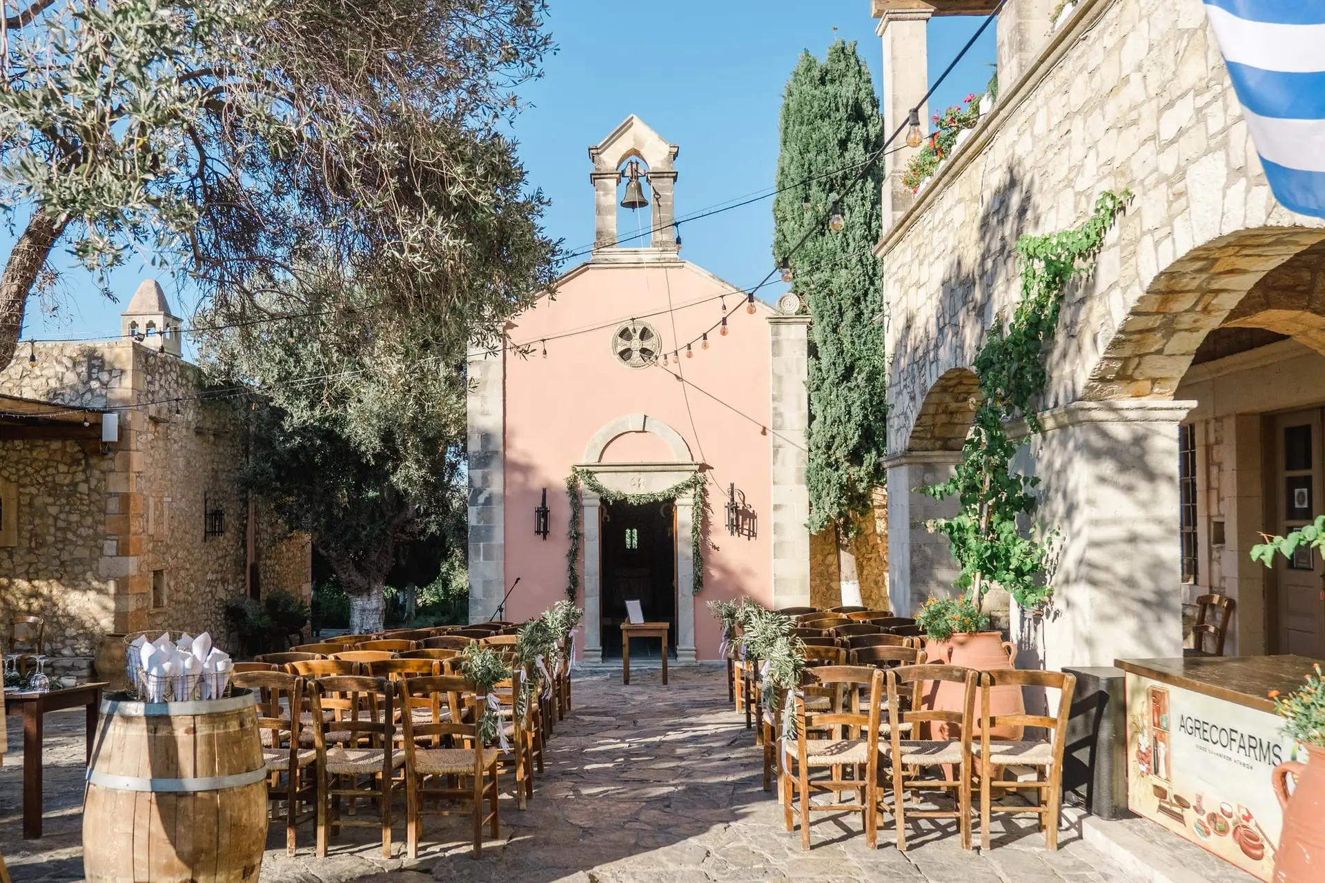 Lieu de cérémonie de mariage à Agreco Farm près de Rethymnon en Crète, chapelle et chaises en bois décorées d’olivier photographiées par Julien Boyer