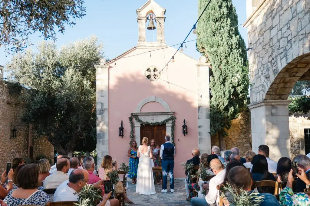 Vue d’ensemble de la cérémonie de mariage à Agreco Farm près de Rethymnon en Crète, chapelle et invités réunis photographiés par Julien Boyer