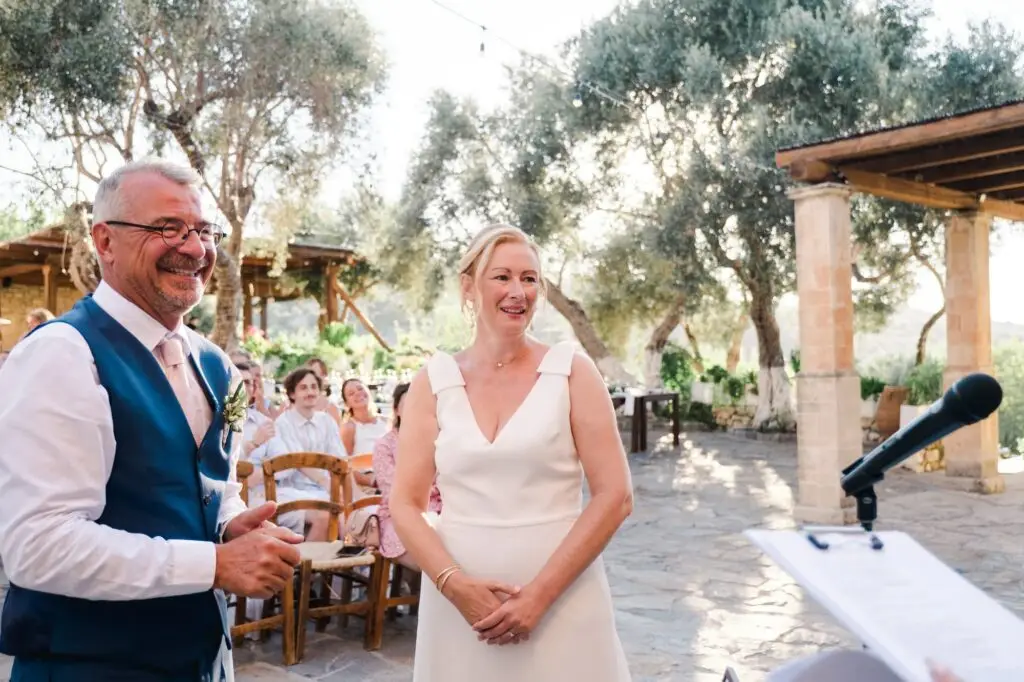 Cérémonie de mariage en plein air à Agreco Farm près de Rethymnon en Crète, couple échangeant ses vœux dans un cadre authentique, photo par Julien Boyer photographe de mariage