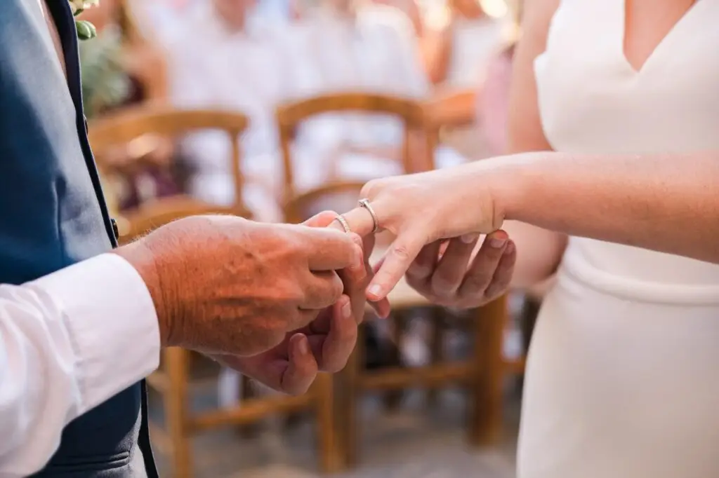 Gros plan sur l’échange des alliances pendant un mariage à Agreco Farm près de Rethymnon en Crète, photo de cérémonie par Julien Boyer photographe de mariage