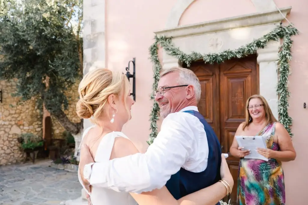 Mariés s’enlaçant après la cérémonie de mariage à Agreco Farm près de Rethymnon en Crète, moment de joie capturé par Julien Boyer photographe de mariage