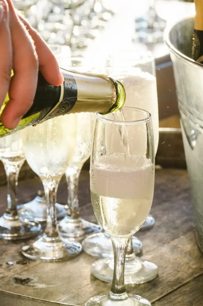 Service du champagne pendant le cocktail de mariage à Agreco Farm près de Rethymnon en Crète, reportage photo par Julien Boyer photographe de mariage