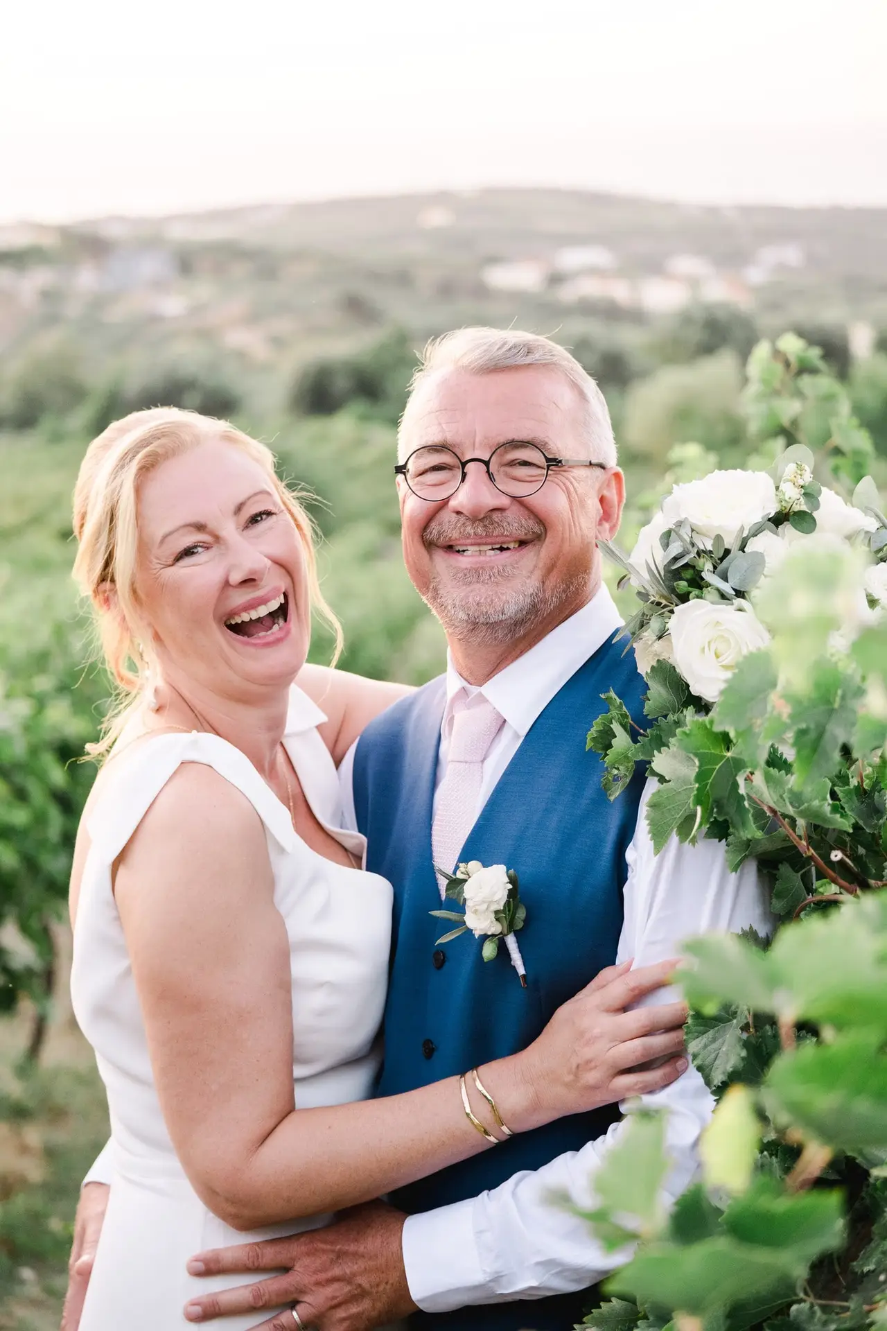 Portrait naturel des mariés dans les vignes à Agreco Farm près de Rethymnon en Crète, moment joyeux photographié par Julien Boyer photographe de mariage