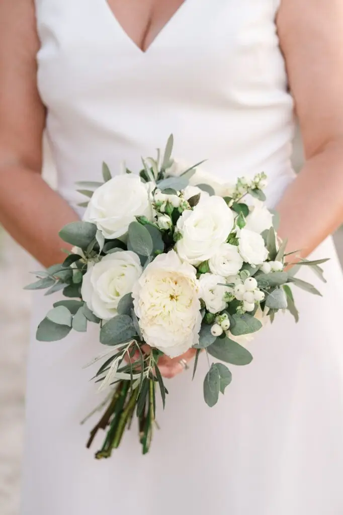 Détail du bouquet de la mariée composé de fleurs blanches et feuillage méditerranéen lors d’un mariage à Agreco Farm en Crète, photo par Julien Boyer photographe de mariage
