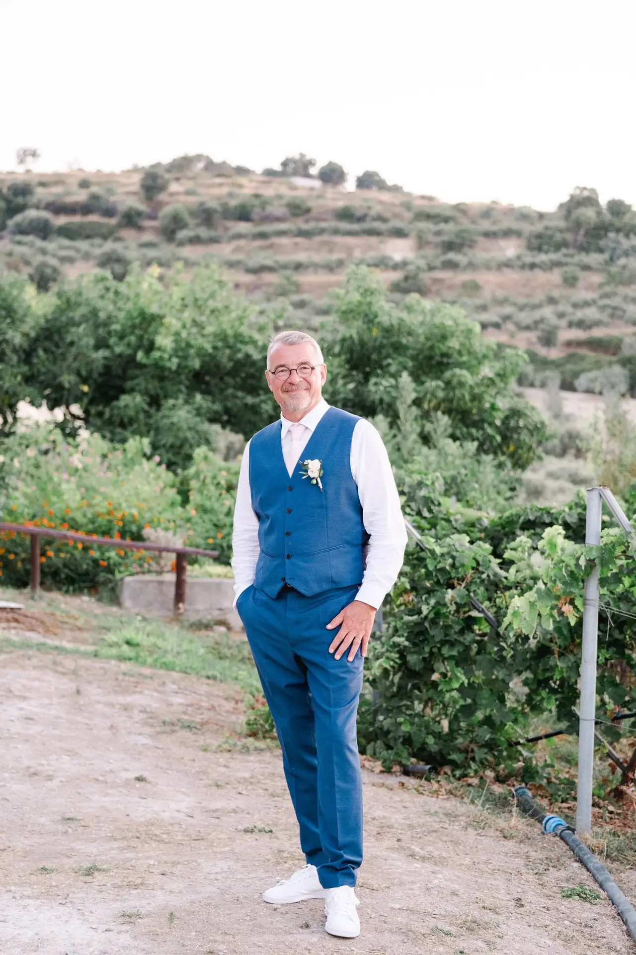 Portrait du marié lors de son mariage à Agreco Farm près de Rethymnon en Crète, costume bleu et décor naturel photographié par Julien Boyer photographe de mariage