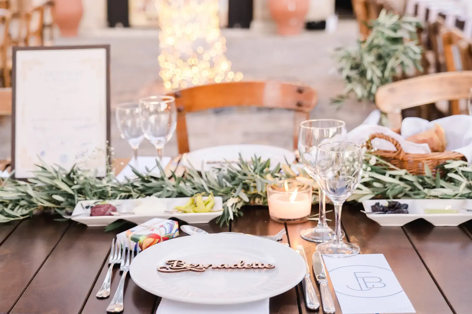 Table des mariés décorée avec feuillage d’olivier, vaisselle élégante et ambiance méditerranéenne lors d’un mariage à Rethymnon en Crète, photo par Julien Boyer photographe de mariage