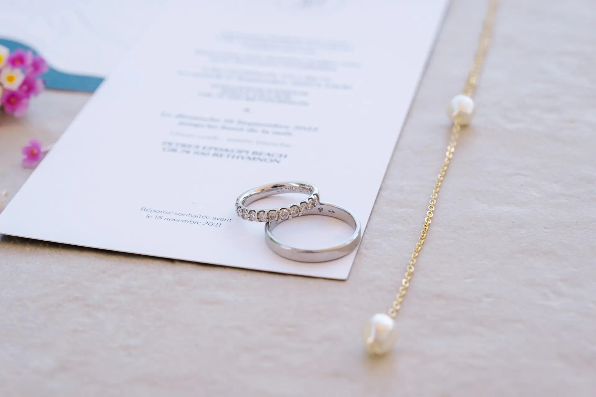 Alliances de mariage posées sur la papeterie lors d’un mariage à Rethymnon en Crète, photographie de détails par Julien Boyer