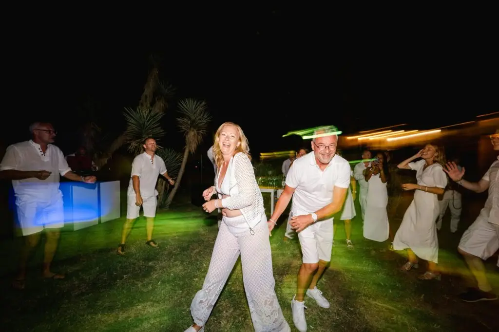Les mariés dansant ensemble pendant la soirée de mariage en Crète, entourés de leurs invités sous les lumières de la nuit