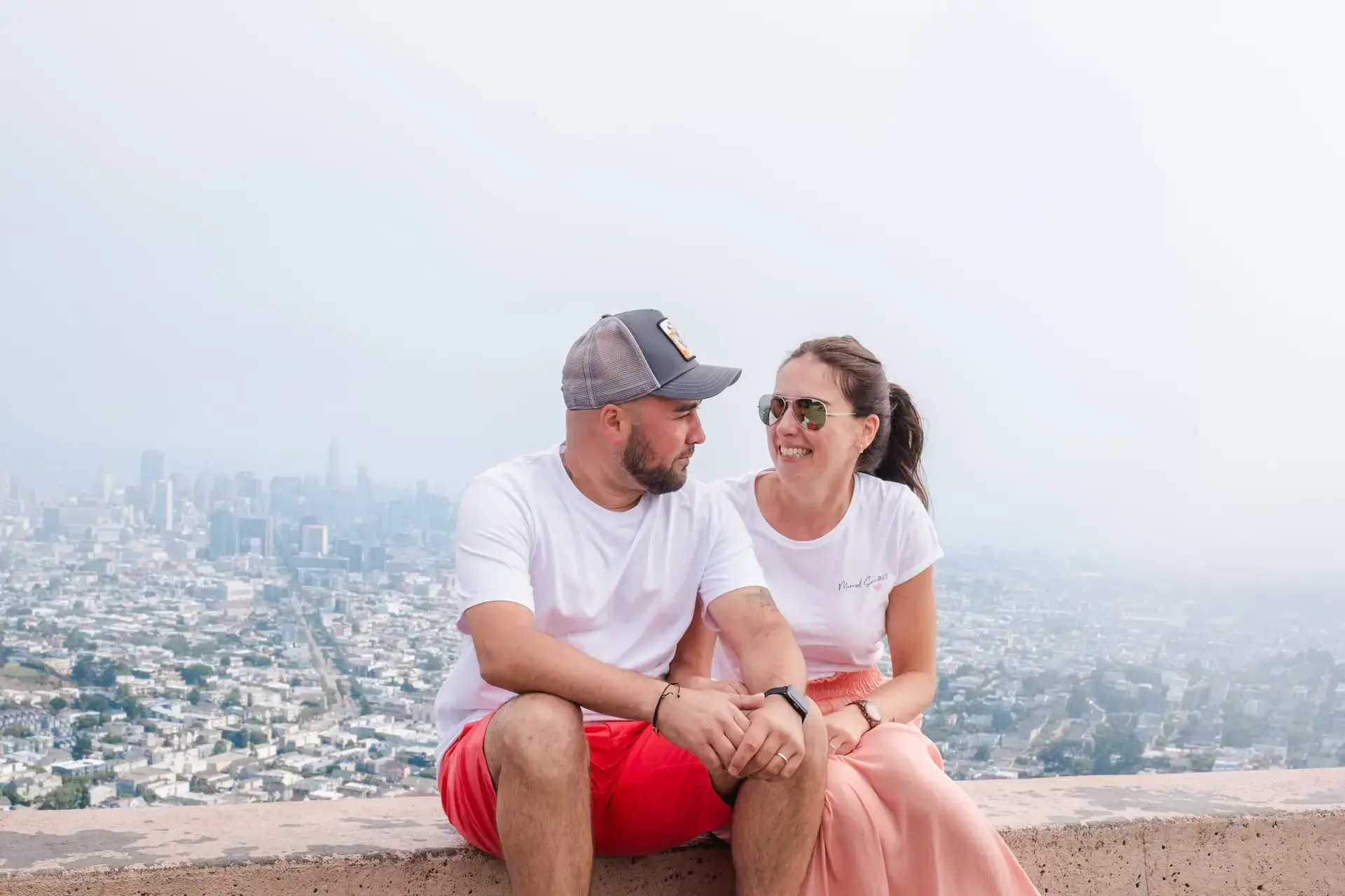 Couple en elopement assis face à la skyline de San Francisco lors d’un mariage intimiste photographié par Julien Boyer