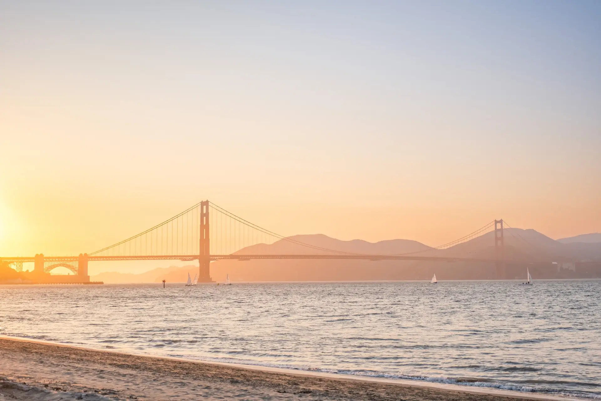 Golden Gate Bridge à la golden hour vu depuis la plage lors d’un elopement à San Francisco photographié par Julien Boyer