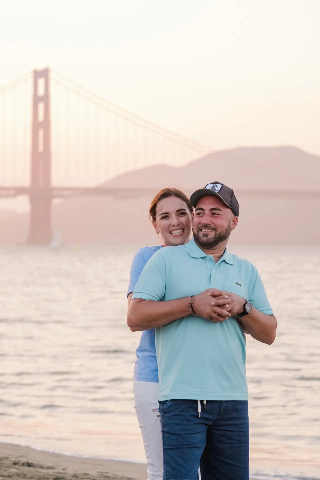 Couple enlacé sur la plage face au Golden Gate Bridge lors d’un elopement à San Francisco photographié par Julien Boyer