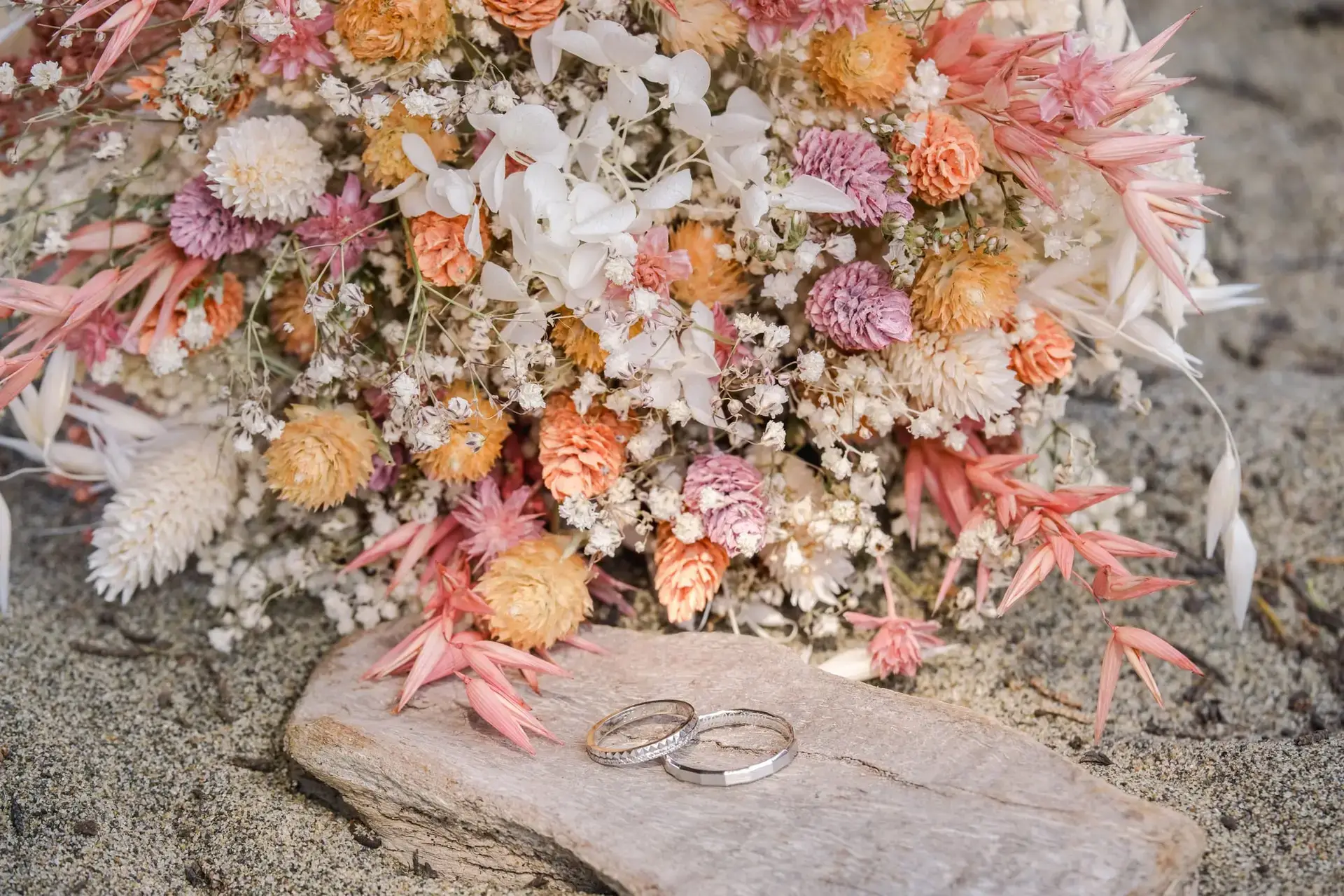 Alliances de mariage posées devant un bouquet de fleurs séchées lors d’un elopement à San Francisco photographié par Julien Boyer