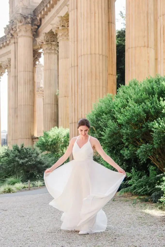 Mariée faisant voler sa robe devant les colonnes du Palace of Fine Arts à San Francisco lors d’un elopement