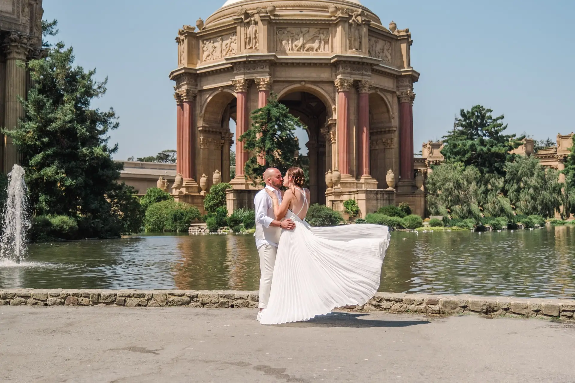 Couple de mariés s’embrassant devant le Palace of Fine Arts à San Francisco lors d’un elopement photographié par Julien Boyer