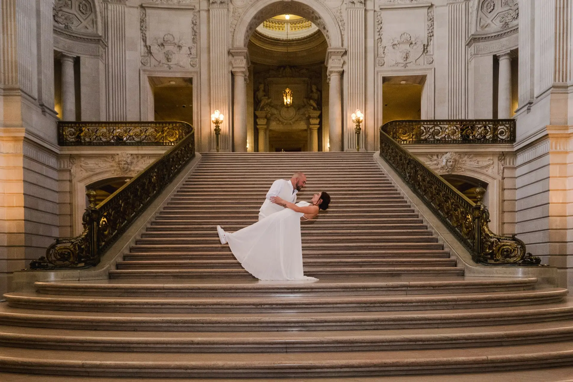 Couple de mariés sur l’escalier monumental du City Hall de San Francisco lors d’un mariage elopement