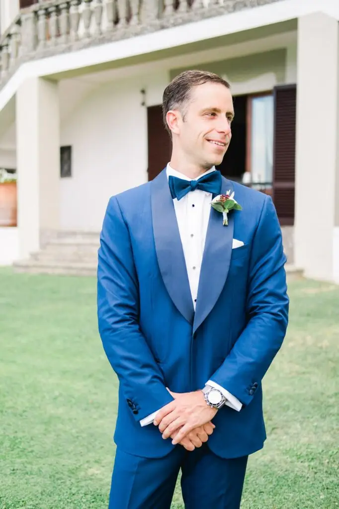 Portrait du marié en costume bleu dans les jardins de la Villa Vistarenni en Toscane, photographie de mariage de destination prise par Julien Boyer.