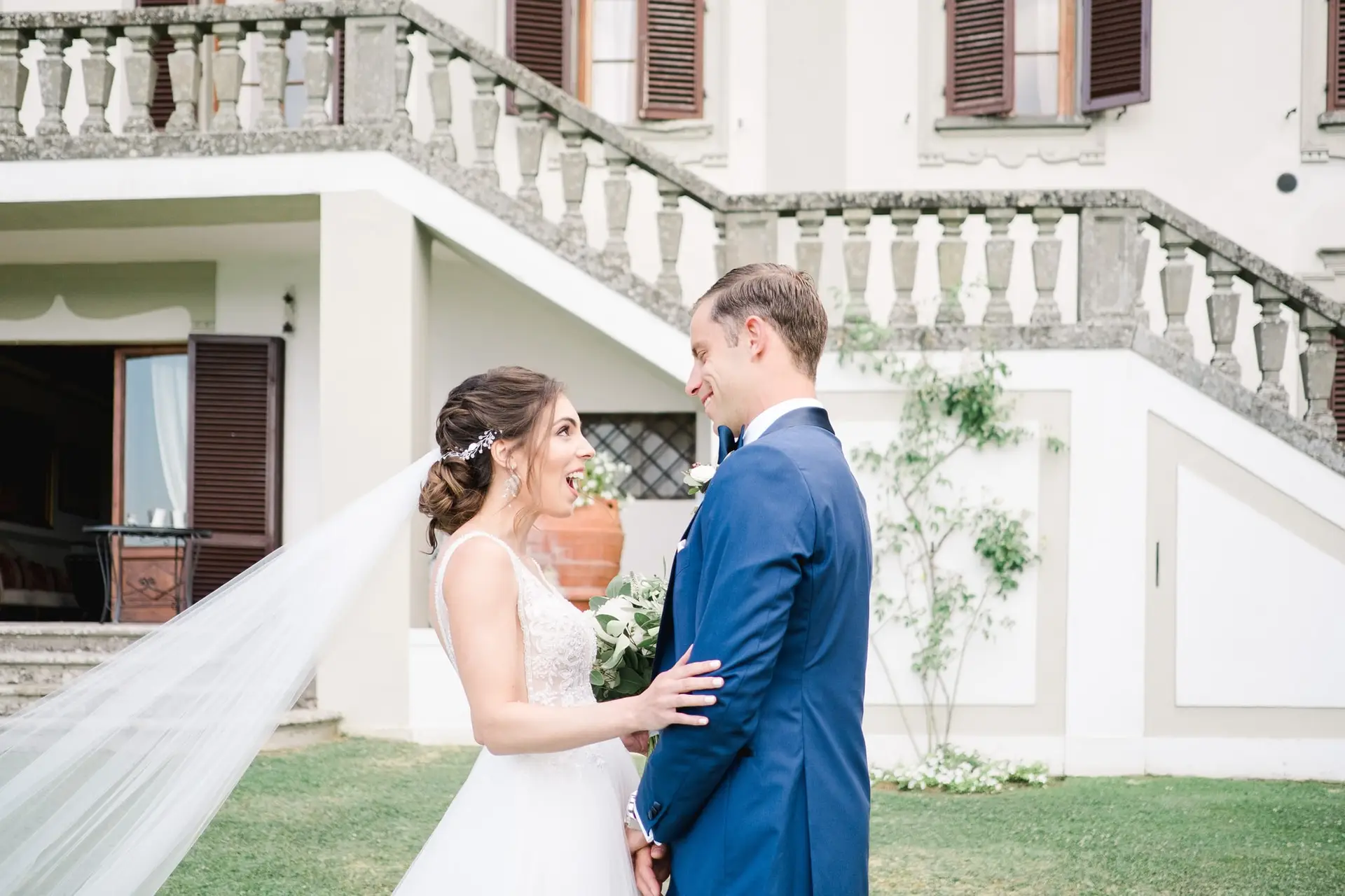 Moment d’émotion entre les mariés lors de leur first look dans les jardins de la Villa Vistarenni en Toscane, photographie de mariage naturelle.