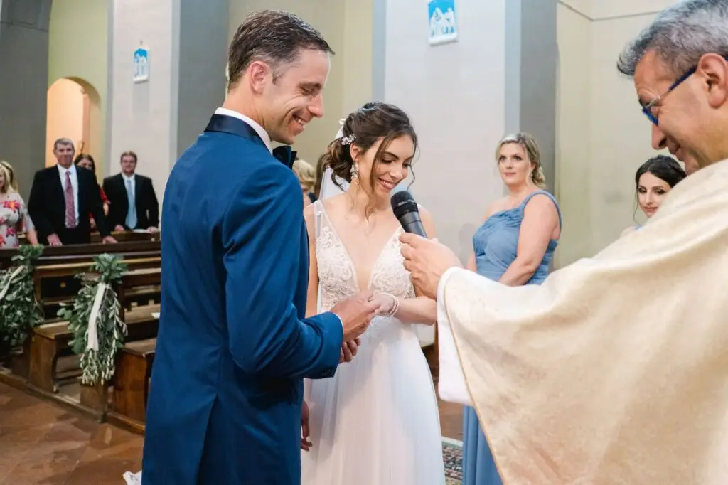 La mariée lit ses vœux pendant la cérémonie religieuse en Toscane entourée de ses proches, photographie prise par Julien Boyer, photographe de destination.
