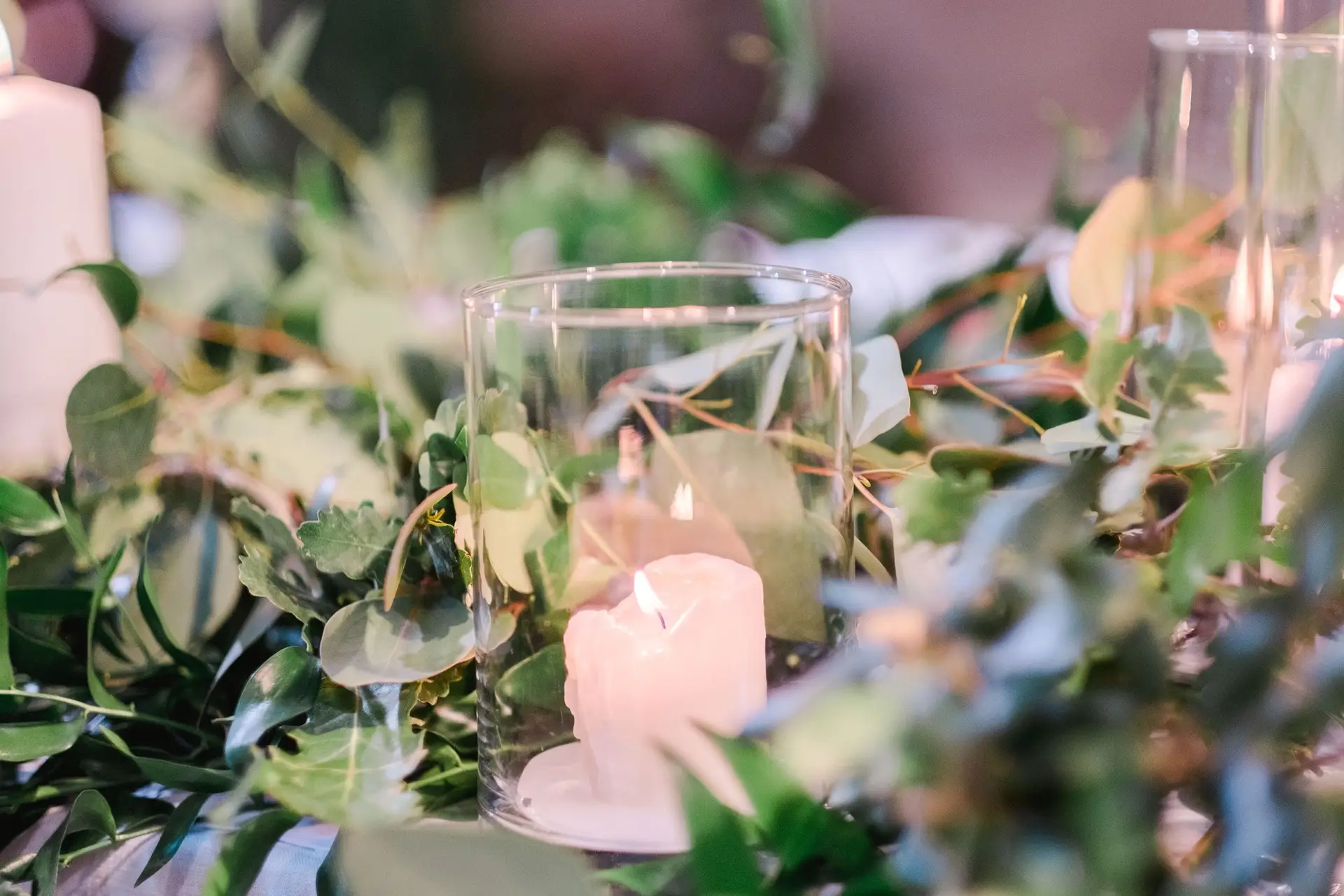 Détail de décoration de table avec bougies et feuillage pour un mariage de destination en Toscane, ambiance élégante et naturelle.