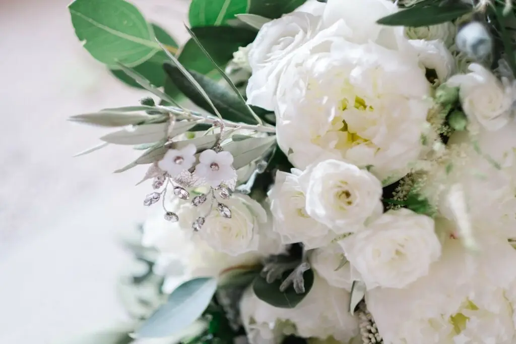 Gros plan sur un bouquet de mariée blanc et feuillage vert, inspiration mariage élégant en Toscane, photographié par Julien Boyer, photographe de mariage de destination.