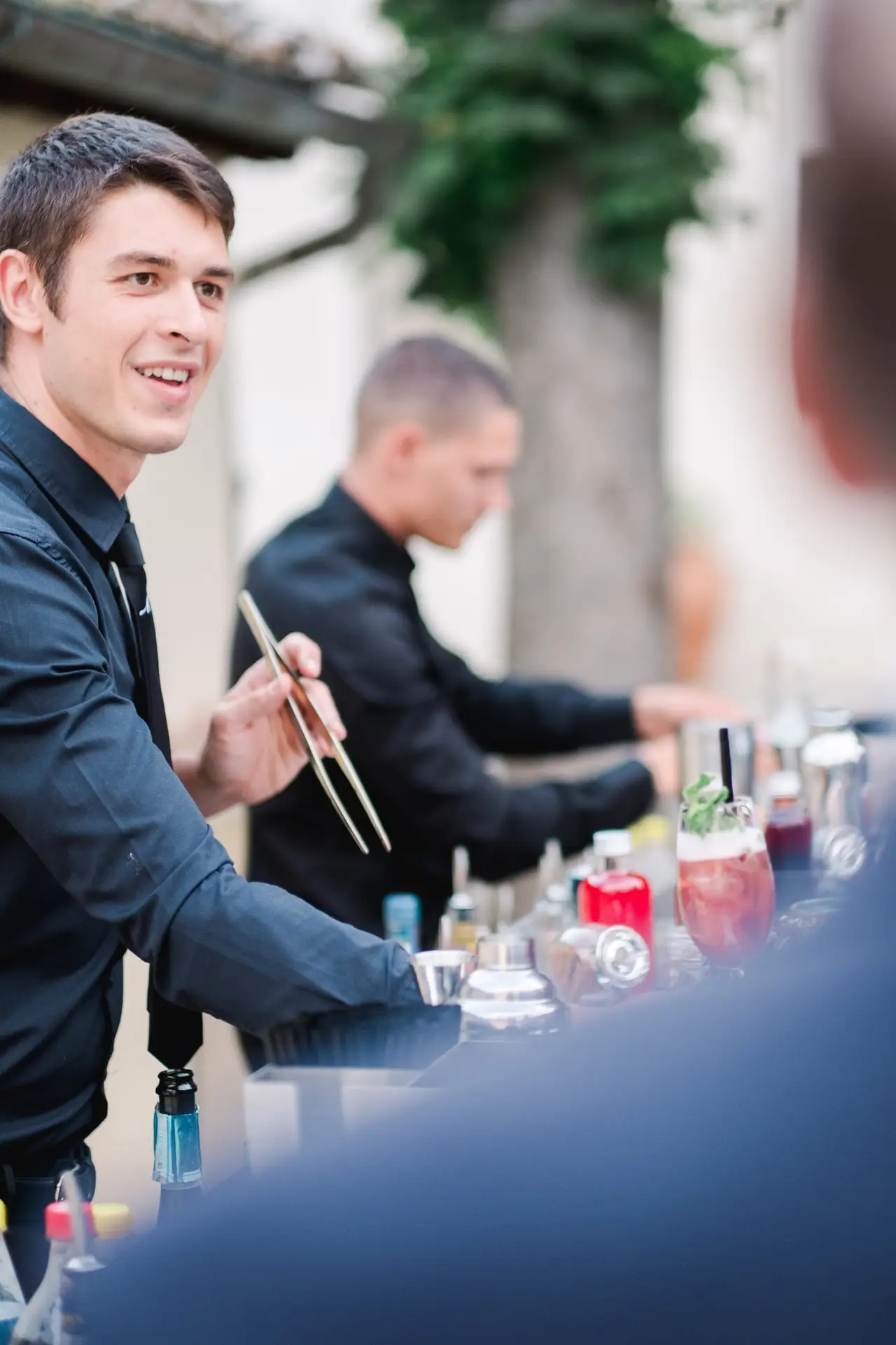Bartender préparant des cocktails lors du vin d’honneur d’un mariage de destination en Toscane, ambiance chic et conviviale.