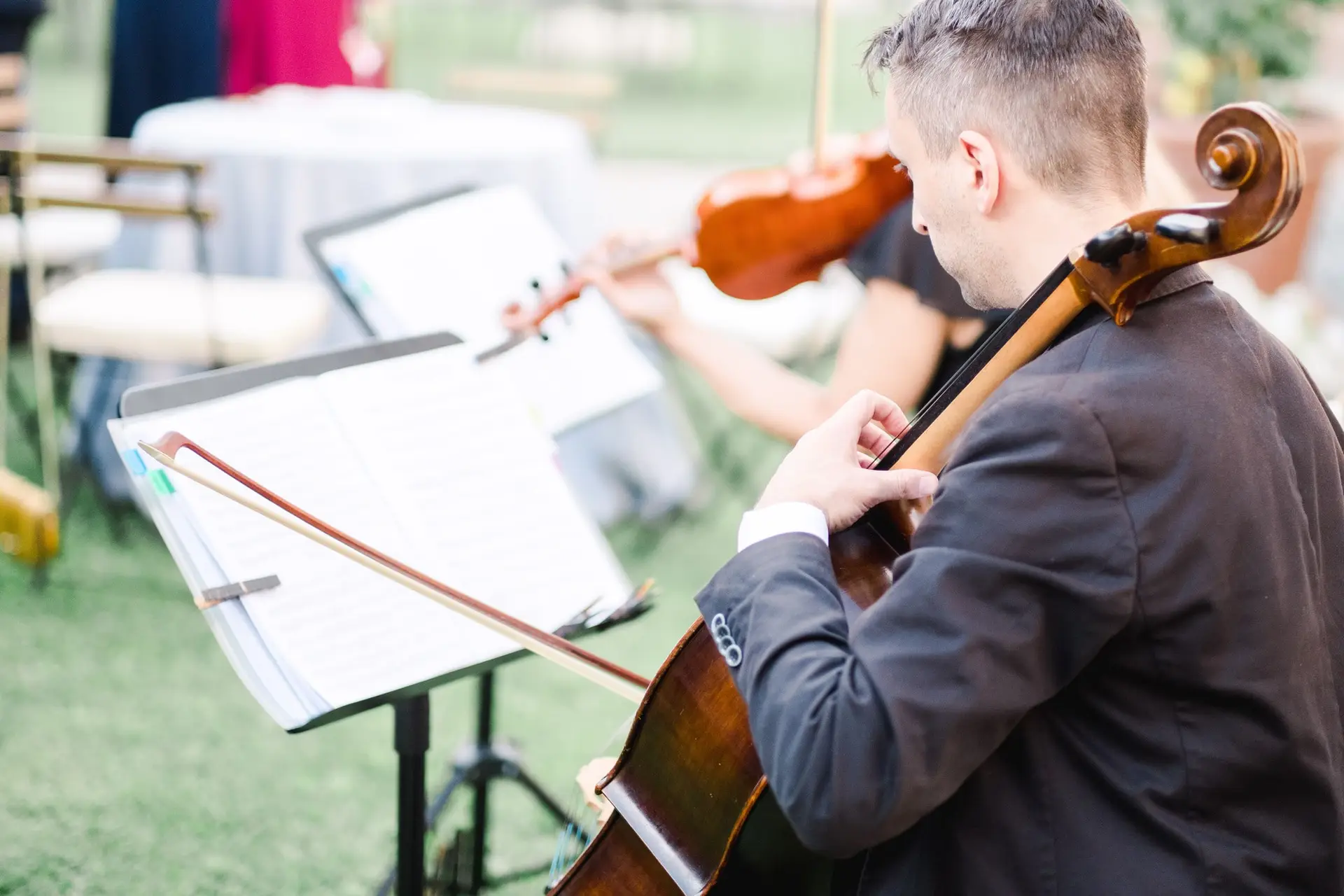 Musicien jouant du violoncelle pendant un mariage en Toscane, animation musicale élégante lors du cocktail en plein air.