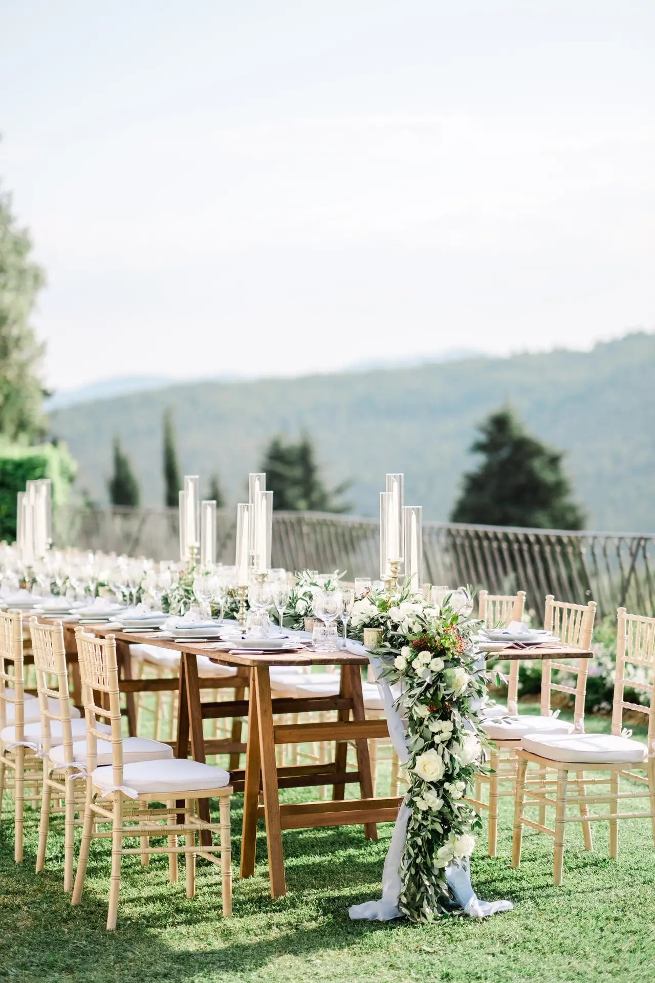 Détail de vaisselle raffinée aux motifs bleus et verrerie élégante pour un dîner de mariage en Toscane.