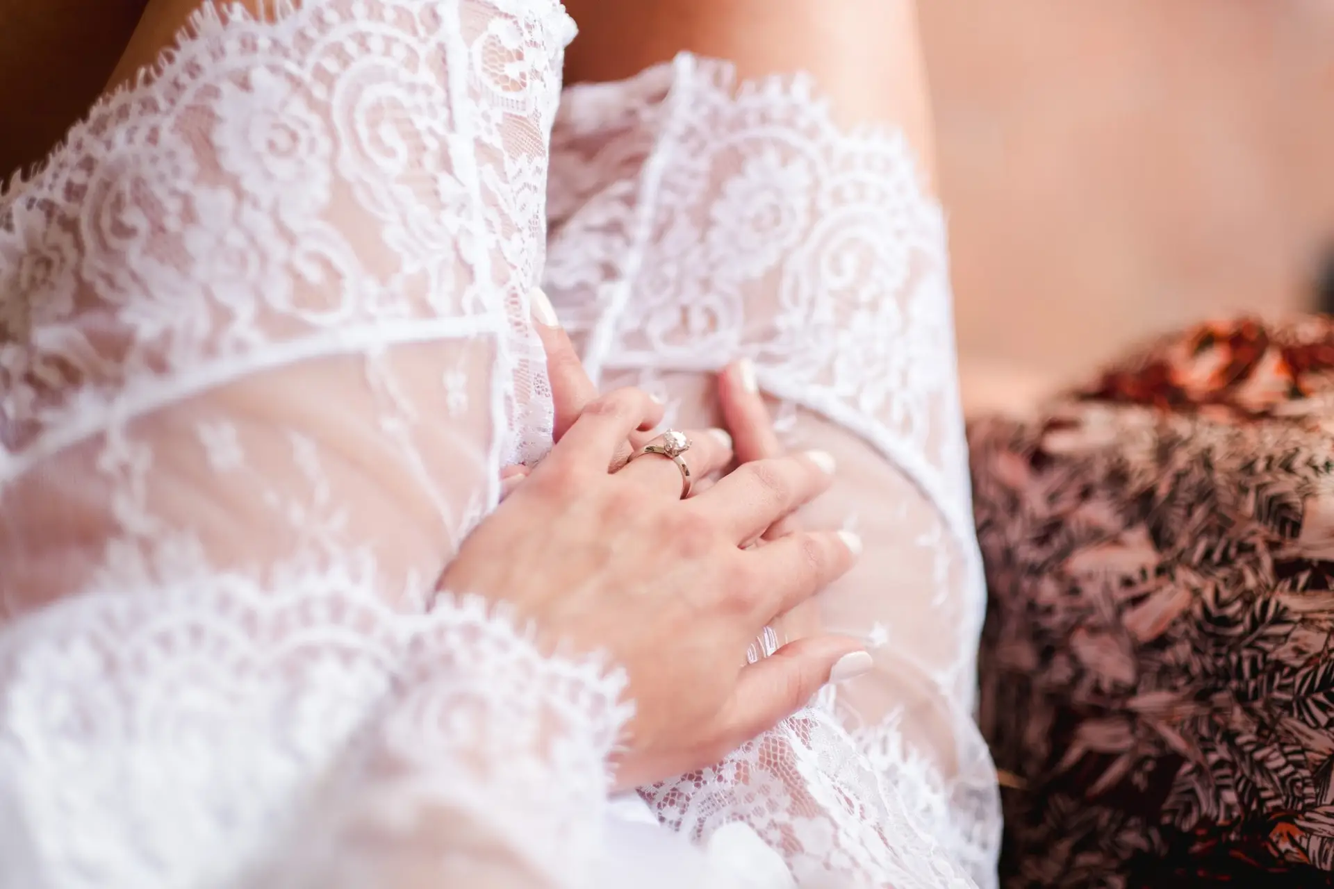 Détail de la robe de mariée en dentelle avec bague de fiançailles, photographie fine art d’un mariage de destination en Toscane.