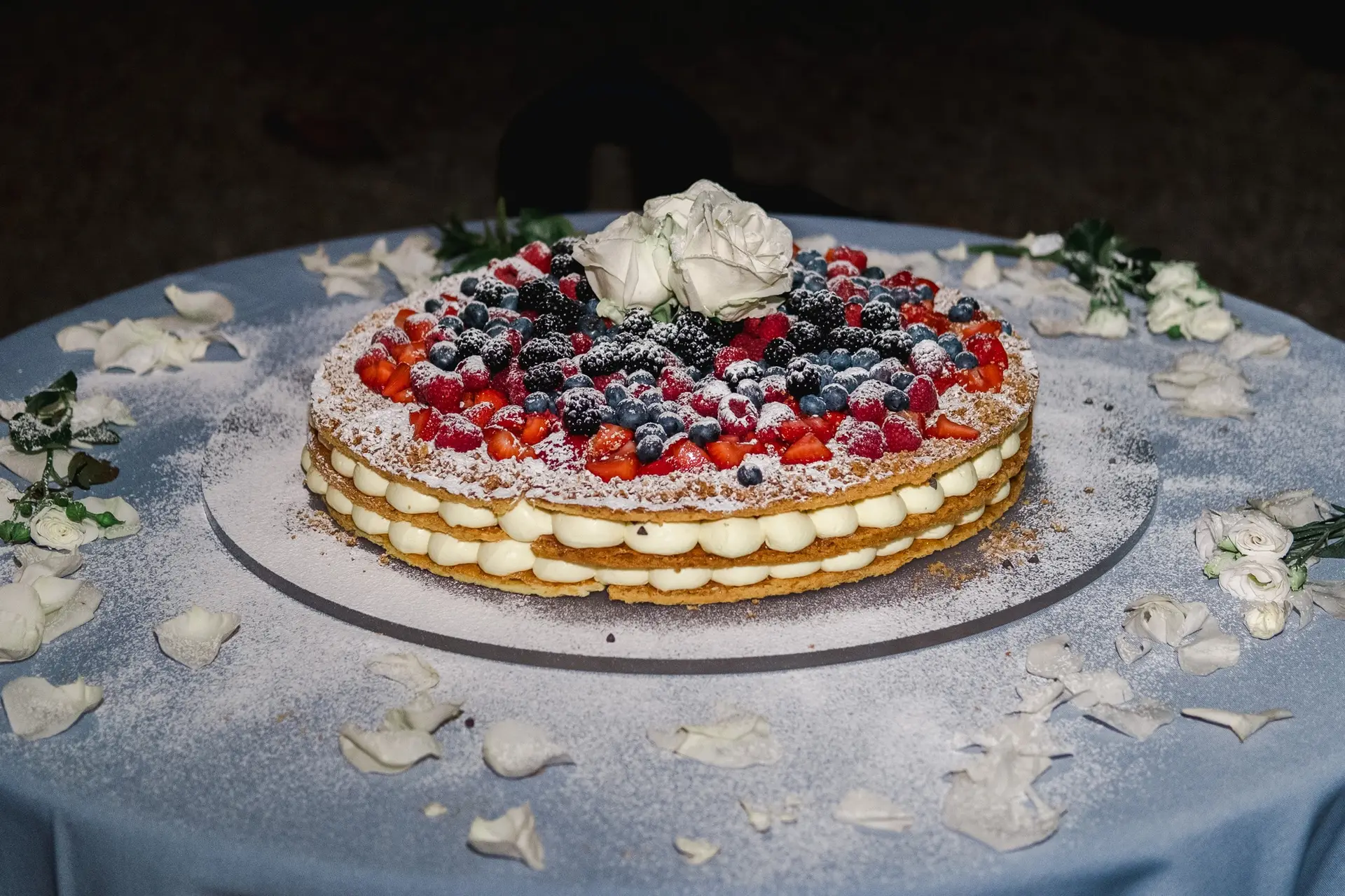 Gâteau de mariage raffiné aux fruits rouges et crème présenté en soirée lors d’un mariage en Toscane, photo de détail prise par Julien Boyer.