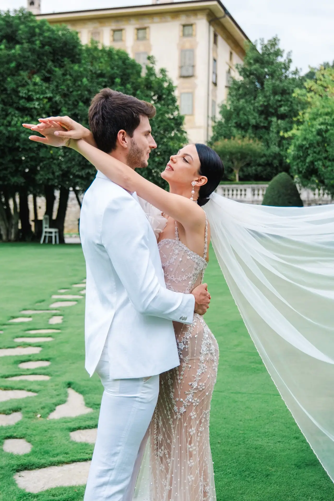 Couple de mariés dans un jardin élégant à la Villa Canton, échangeant un regard complice dans un cadre raffiné, photographiés par Julien Boyer.
